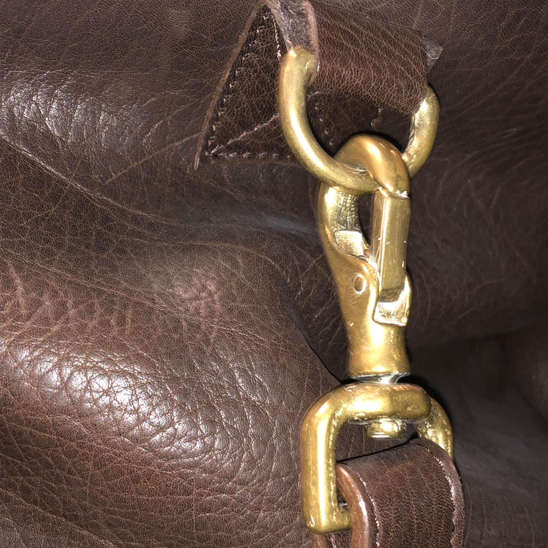 Close up view of one of the high-quality metal clasps that connects the strap to the bag.